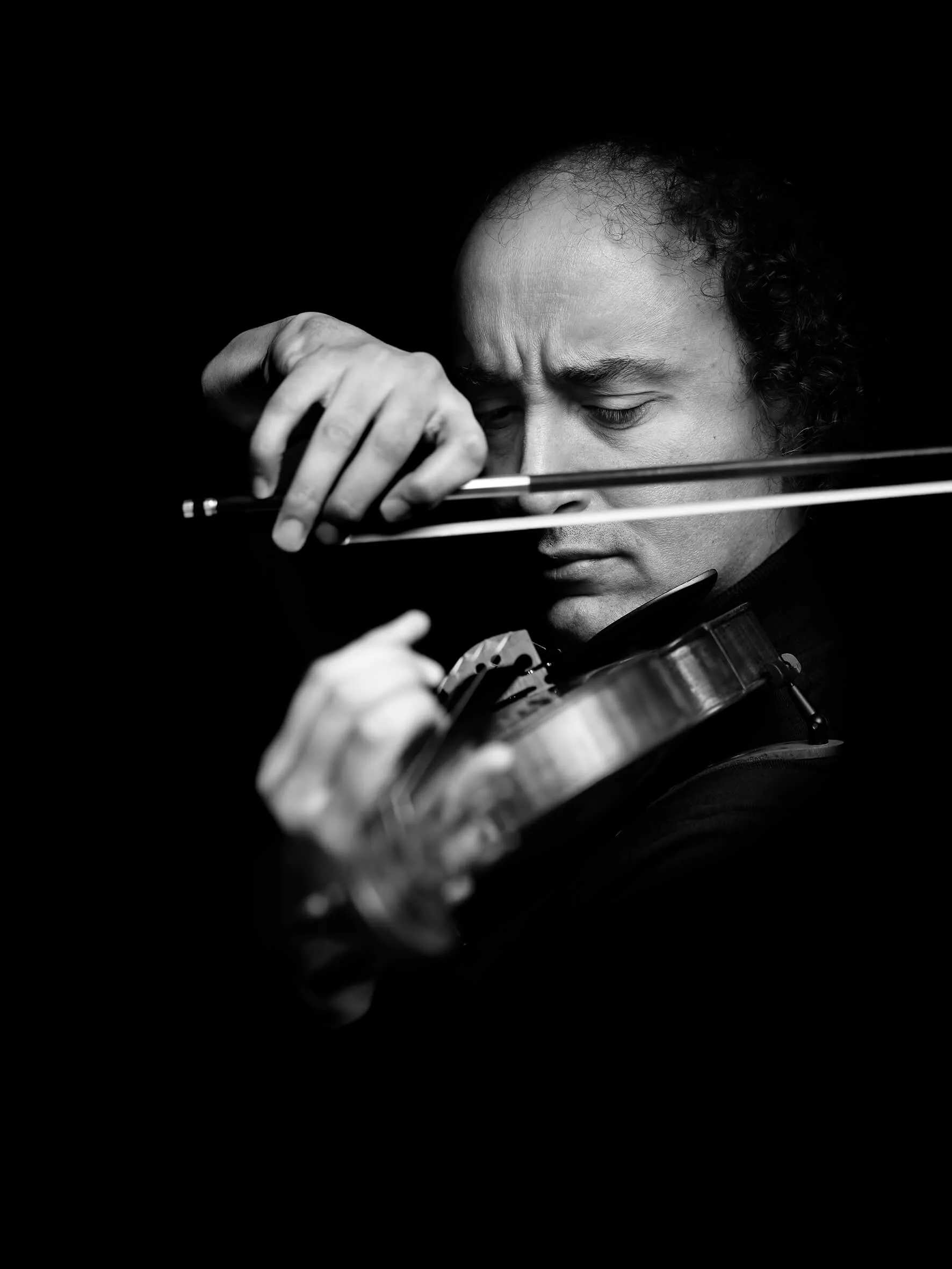 Mario Hossen playing the violin with his eyes closed, black-and-white portrait