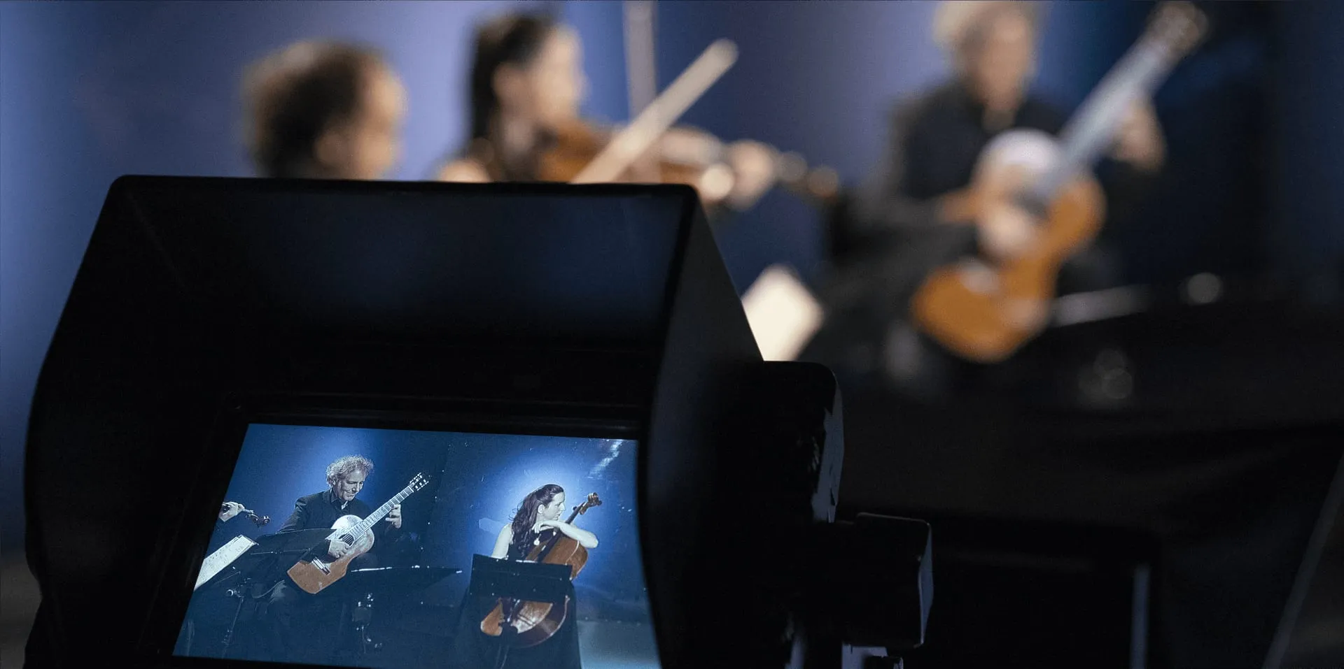 A camera monitor showing the ensemble during a studio recording